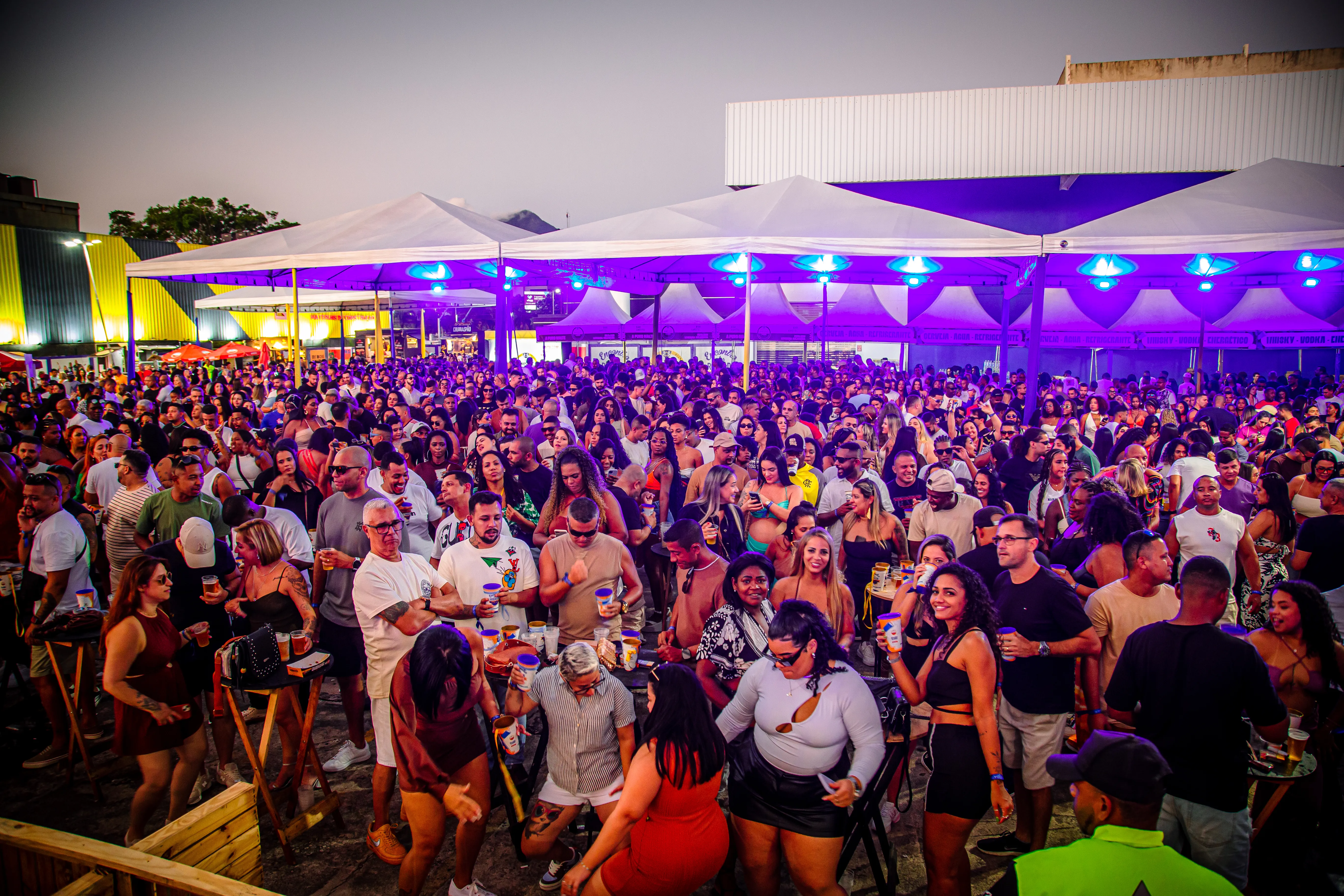 Público com as mãos para o alto animando a pista iluminada na segunda edição do Encontro das Rodas de Samba